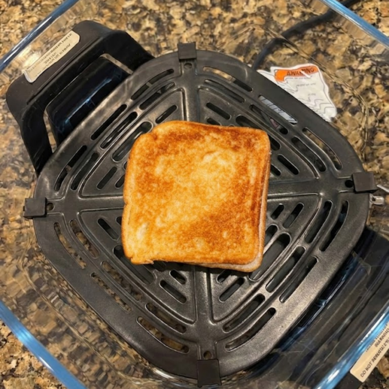 A Toastie cooking inside Ninja Crispi on air fry mode