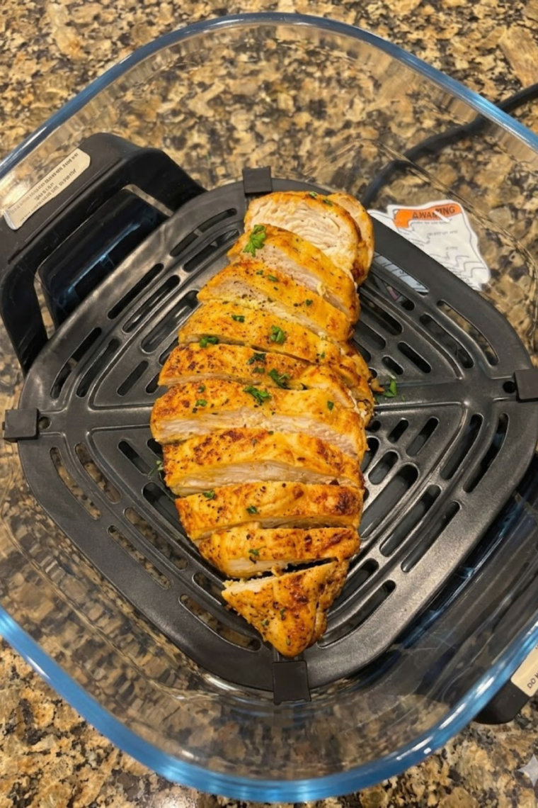 Sliced ginger-garlic chicken breasts topped with green onions and sesame seeds