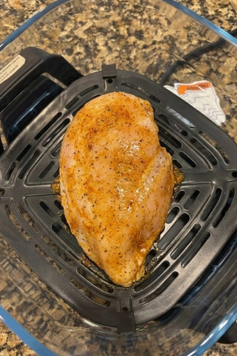 Chicken breasts arranged in single layer inside Ninja Crispi container