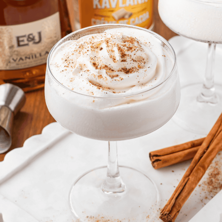 Frozen Brandy Alexander in Ninja Slushi machine being poured into a chilled glass topped with nutmeg