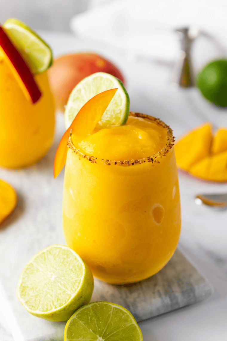 frozen mango margarita in glass with salt rim and lime wedge