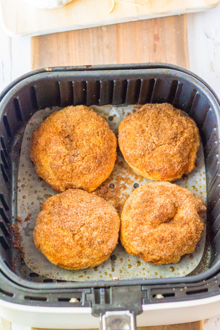 Air fryer method for cinnamon crunch bagels showing bagels placed on parchment in the basket, then air fried at 350&deg;F until golden brown and finished cooling on a wire rack.