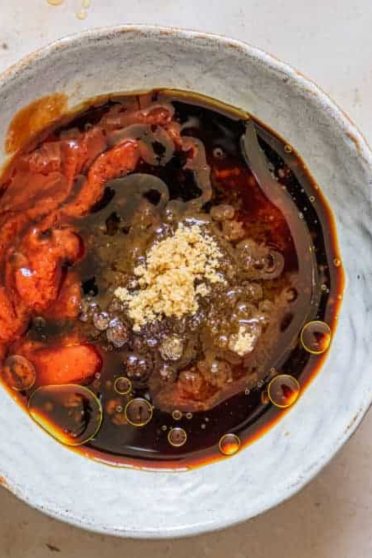 Whisking barbecue sauce ingredients together in a saucepan before heating