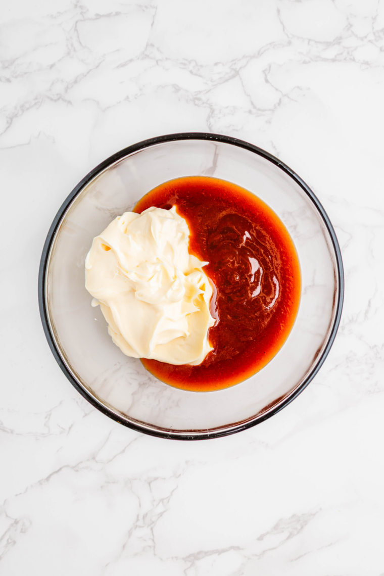 Mixing bowl with mayonnaise, ketchup, mustard, honey, and barbecue sauce being combined for signature sauce base