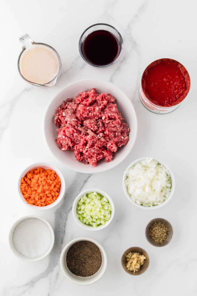 Ingredients needed for Slow Cooker Bolognese Sauce on kitchen table.