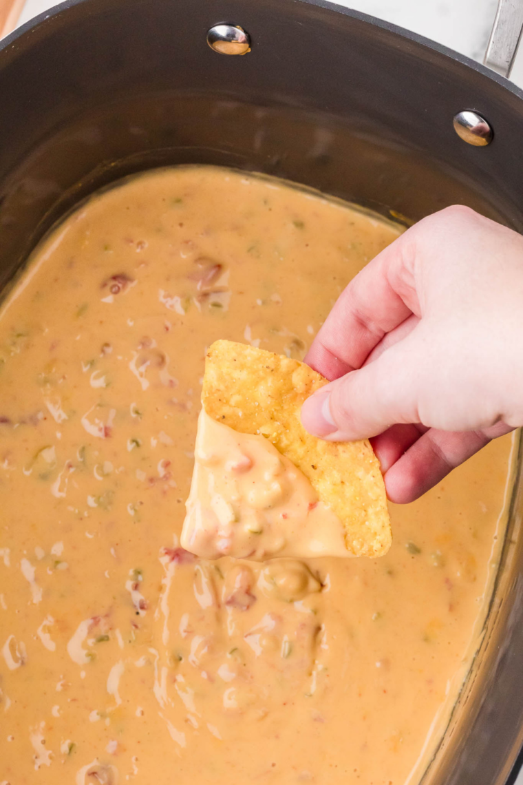 Cheesy Velveeta queso in crockpot with spoon perfect for dipping tortilla chips
