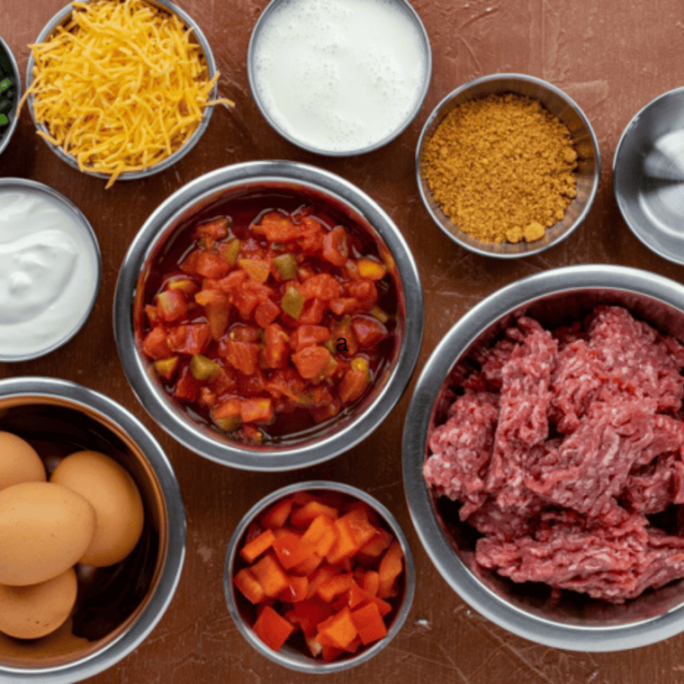 Ingredients for venison casserole including ground venison, potatoes, cheddar cheese, sour cream, and cream of mushroom soup