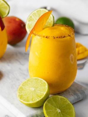 frozen mango margarita in a glass with salt rim and lime wedge