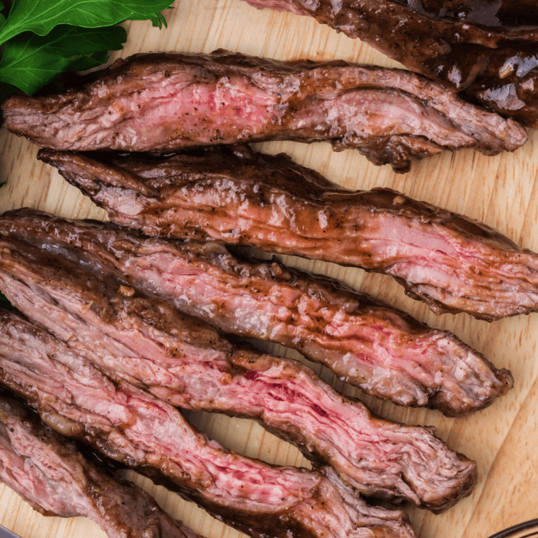 Steak strips marinating in a glossy Soy Ginger Sesame Marinade topped with sliced green onions
