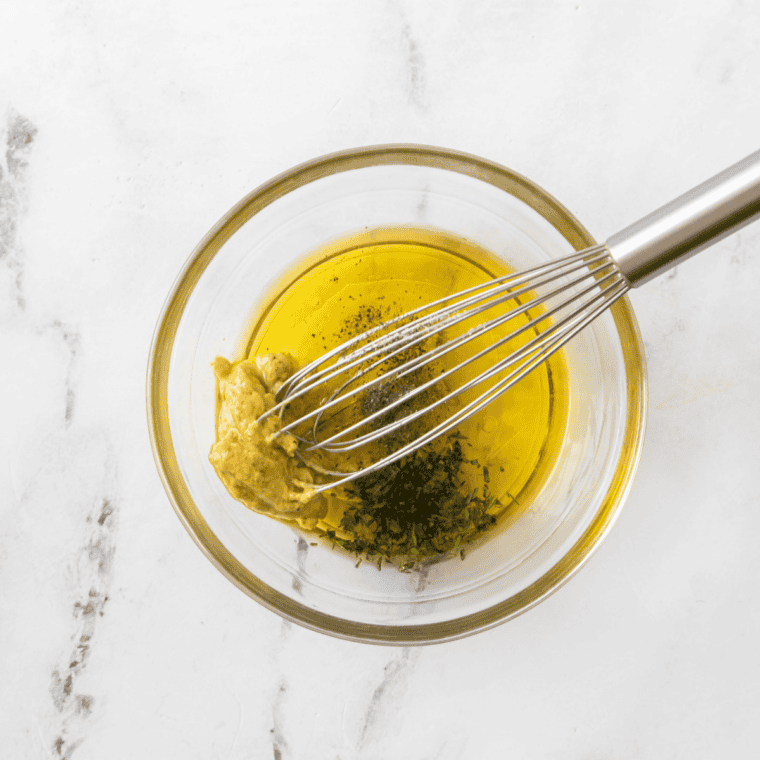 Steak marinating in a dark, savory Classic Steakhouse Marinade with soy sauce, Worcestershire, and minced garlic in a glass dish