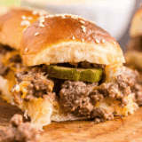 Air Fryer Black Currant Smashburger Sliders stacked on a wooden board with melted cheese, pickles, and special sauce
