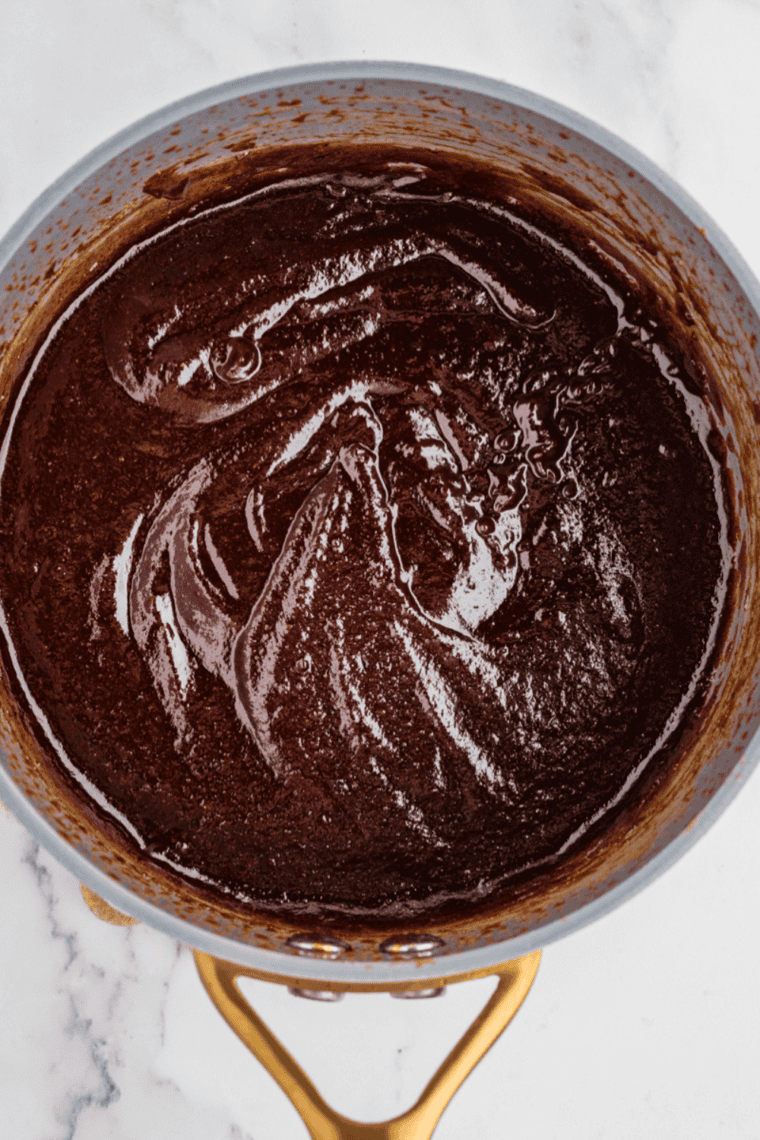 Jack Daniel's whiskey glaze simmering in a saucepan and reducing to a thick, dark, glossy sauce