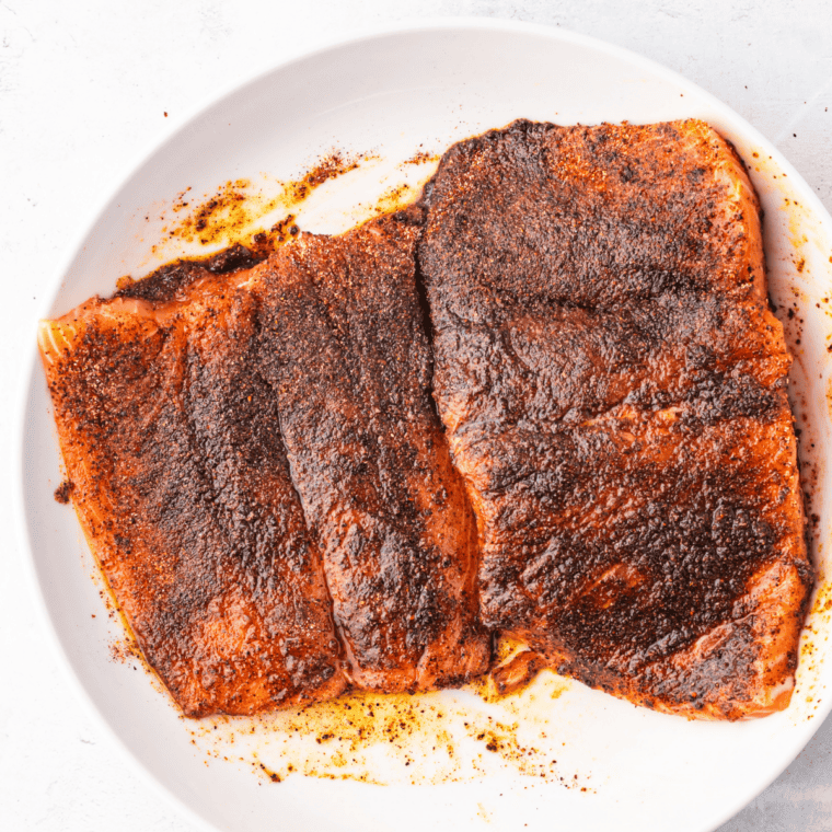Raw salmon fillets patted dry and seasoned with salt, pepper, and garlic powder before air frying