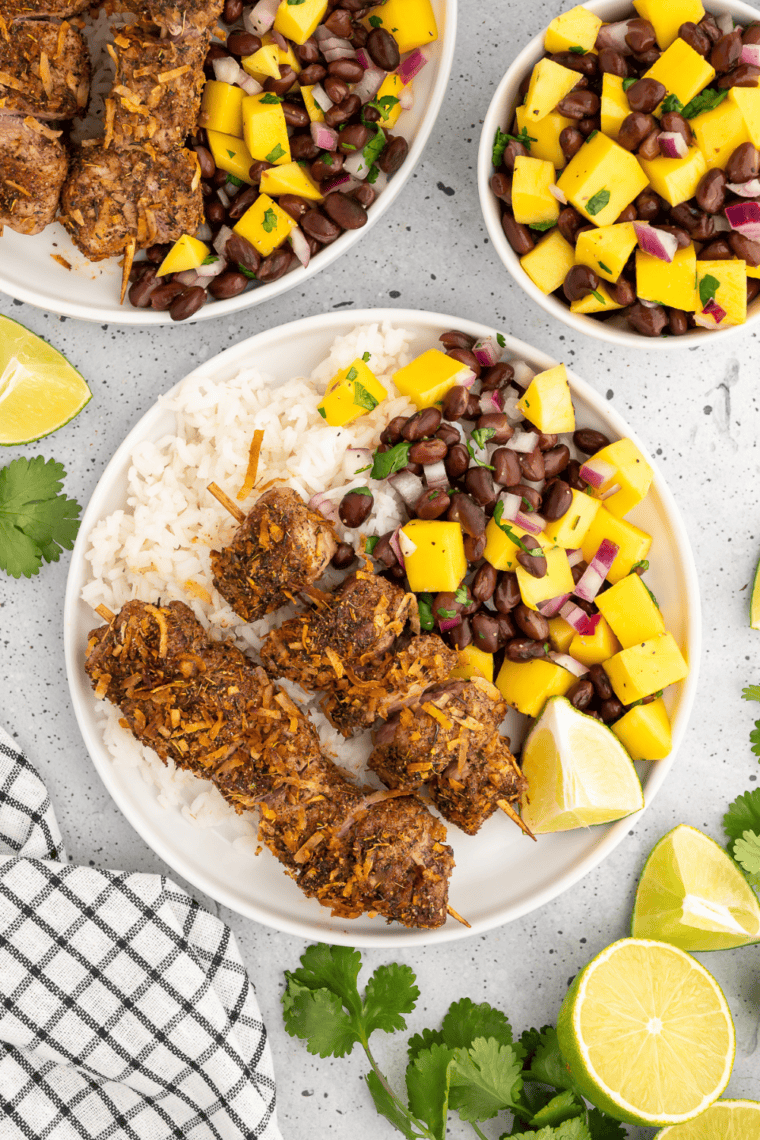 Plate of air fryer jerk pork skewers served with black bean mango salsa.