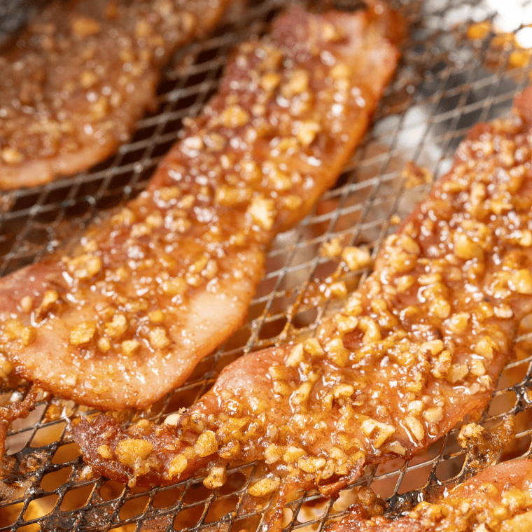 Finished air fryer praline bacon resting on a wire rack as the candied coating hardens
