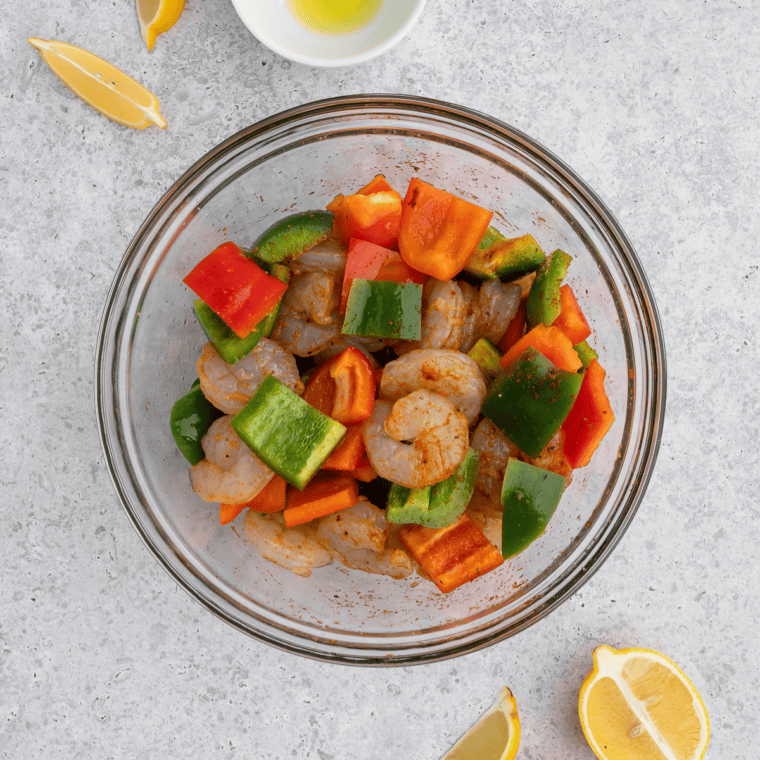 Seasoned shrimp arranged in a single layer in the air fryer basket before cooking at 400°F