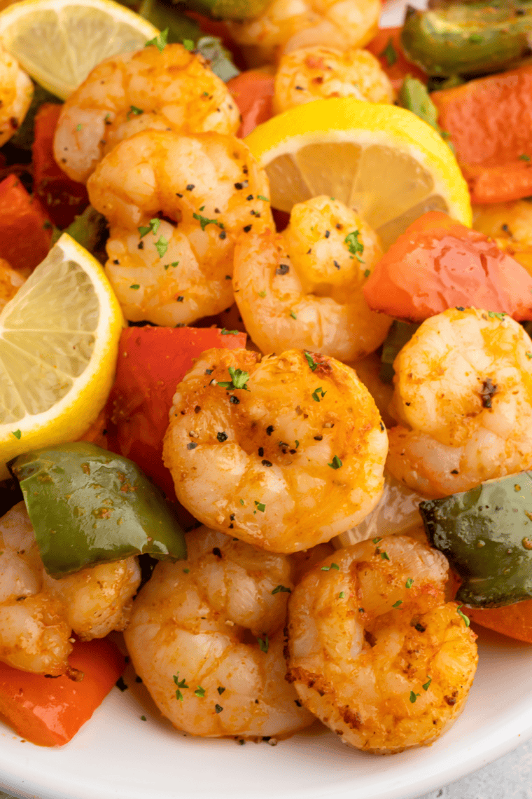 Cilantro-lime crema being drizzled over shrimp in an air fryer shrimp taco bowl