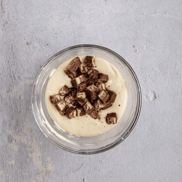 Chopped Snickers bars folded into cheesecake batter poured over a graham cracker crust