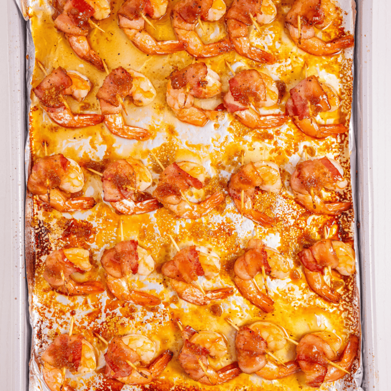 Bacon wrapped shrimp baking on a wire rack over a sheet pan in the oven