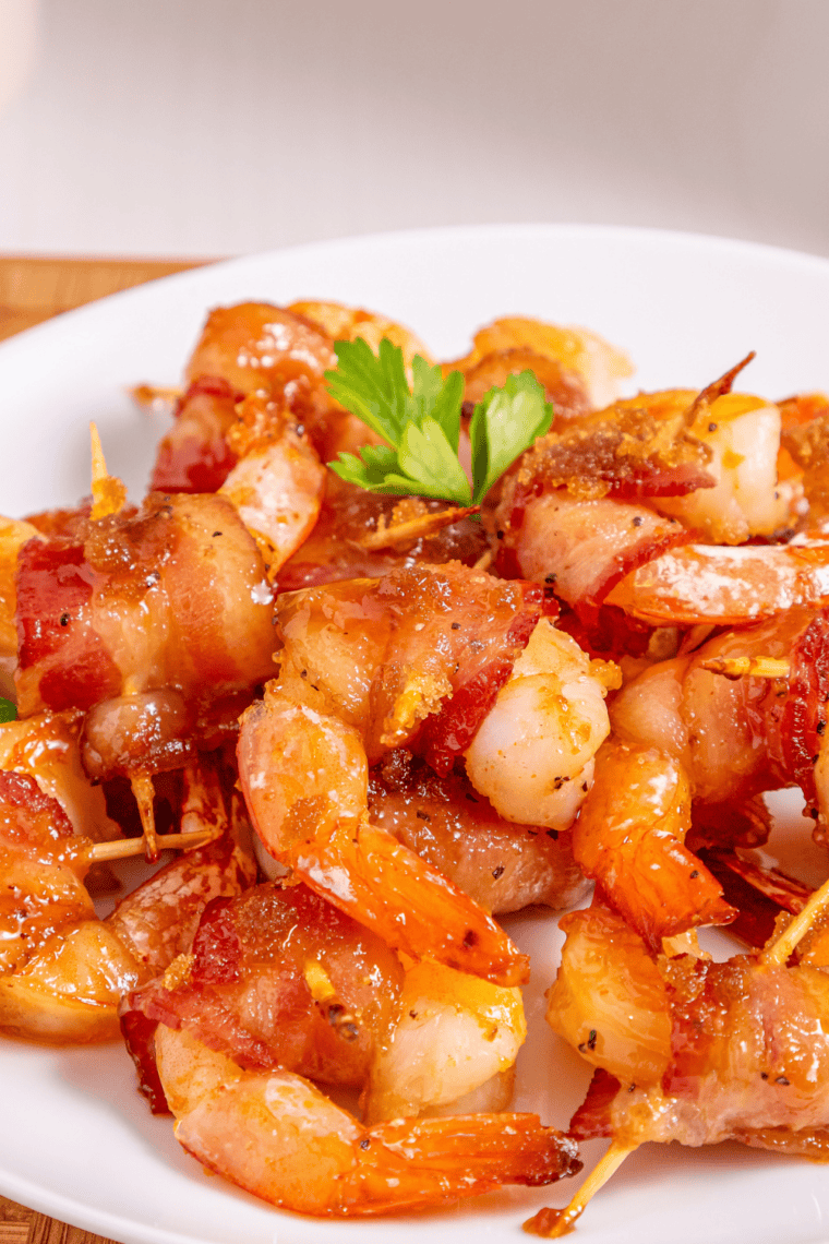 Close-up of a bitten bacon wrapped shrimp showing the melty cream cheese center