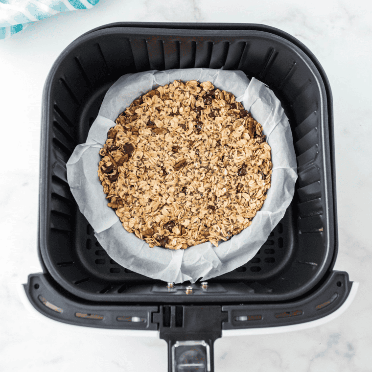 Copycat Bear Naked granola pressed into an even layer on a parchment-lined sheet pan