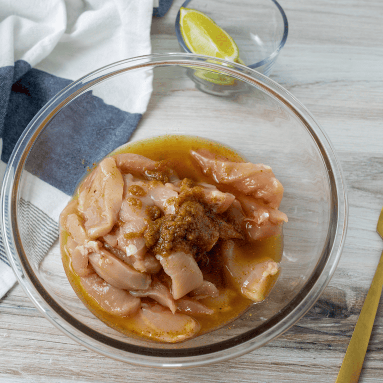 Sliced chicken and vegetables tossed with oil and fajita seasoning for Blackstone chicken fajitas
