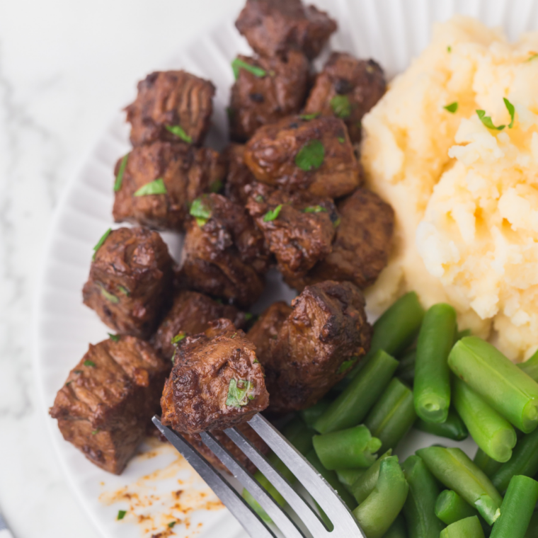 Juicy Blackstone steak bites seared on a flat top griddle with garlic butter glaze
