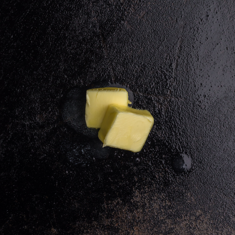 High-smoke-point oil spread in a thin layer across a hot Blackstone flat-top