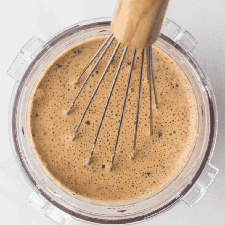Whisking milk, cream, sugar, and coffee into a smooth ice cream base in a bowl
