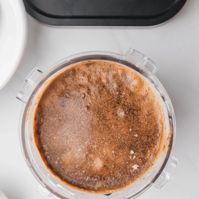 Coffee ice cream base poured into a Ninja Creami pint container before freezing