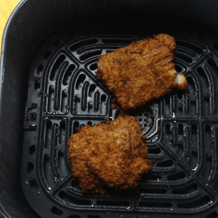 Panko-breaded fish fillets in an air fryer basket for a homemade BK Big Fish sandwich