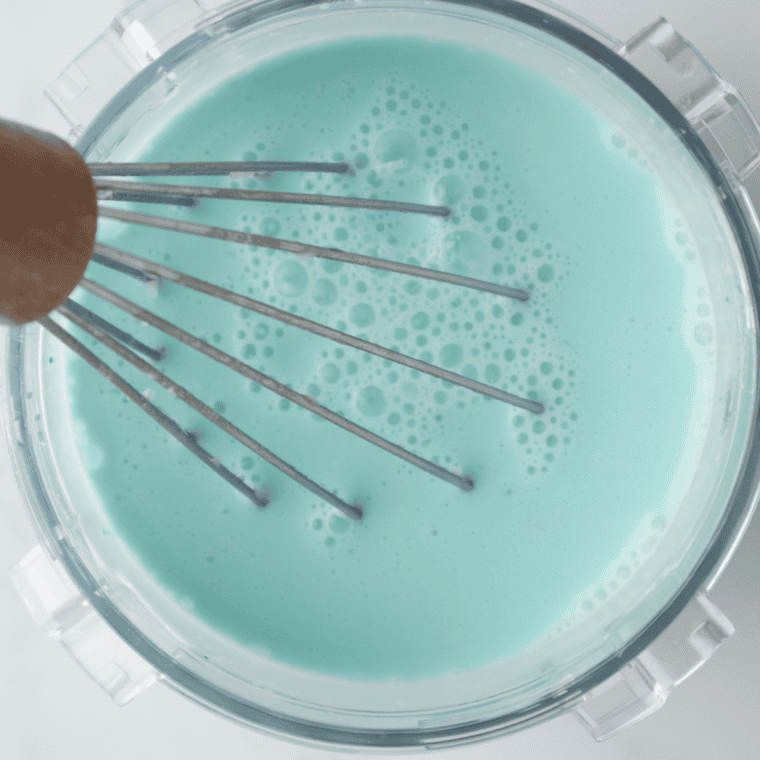 Whisking cotton candy ice cream base in a bowl until smooth and blue