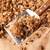 Copycat KIND granola clusters piled in a glass jar with big golden chunks