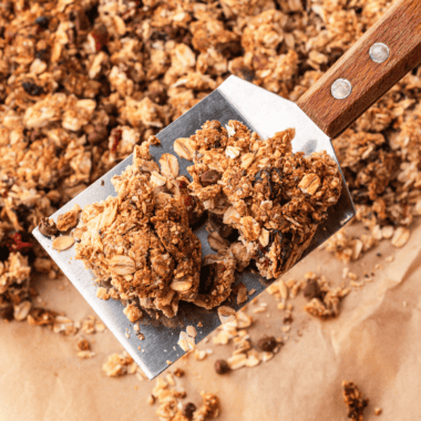 Copycat KIND granola clusters piled in a glass jar with big golden chunks