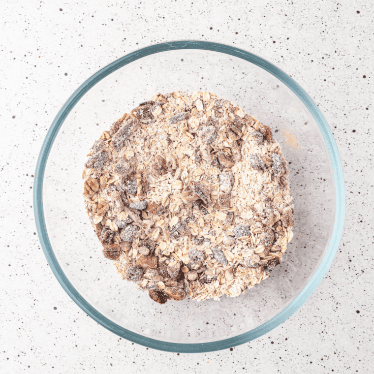 Rolled oats, multigrain blend, nuts, and cinnamon combined in a large mixing bowl.