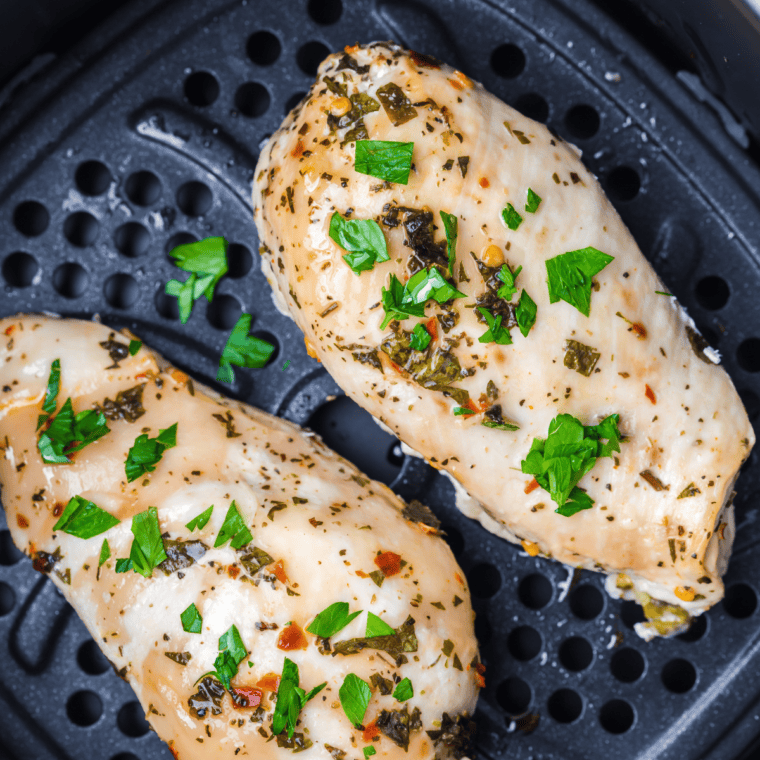 Grilled lemon pepper marinated chicken breasts on a plate with lemon wedges