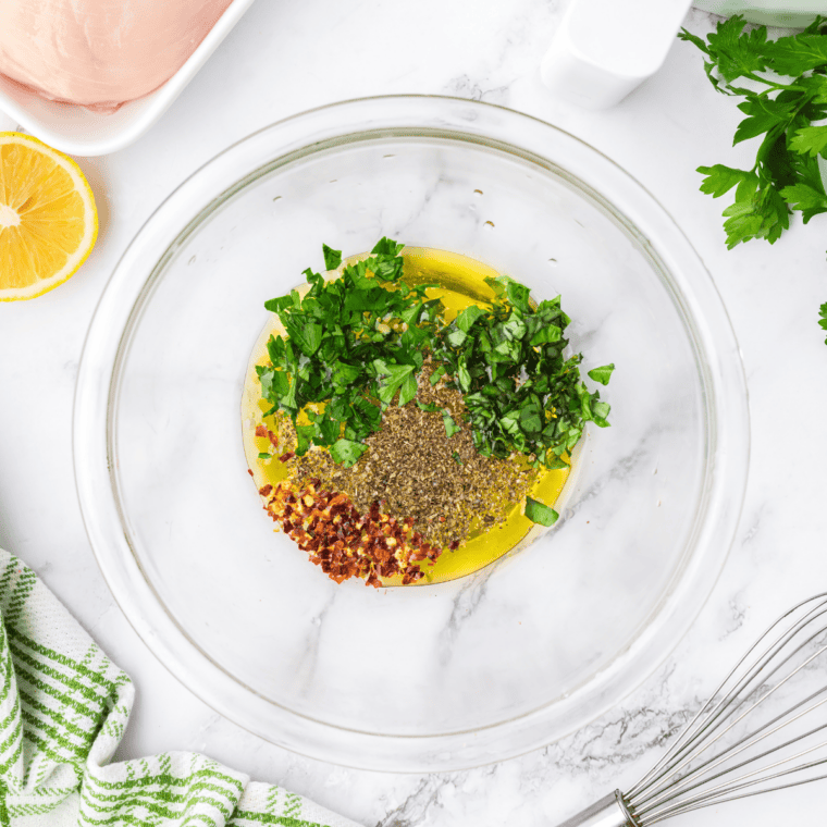 Water, vinegar, lemon juice, and olive oil whisked together in a bowl to make copycat Lawry's lemon pepper marinade