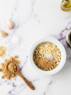 Homemade Lawry&rsquo;s seasoned salt blend in a small jar with spices scattered around.