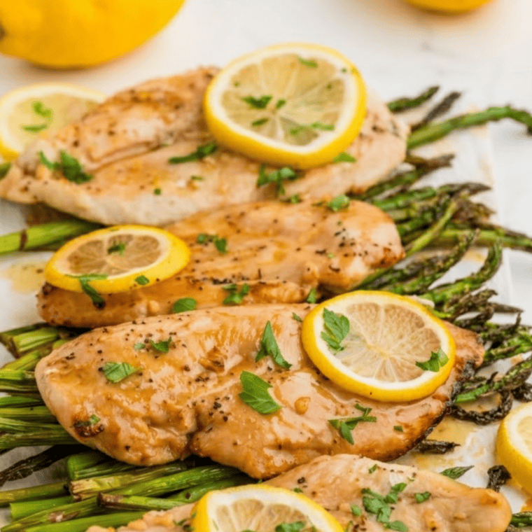 Copycat McCormick lemon pepper seasoning on grilled chicken breast with roasted asparagus on a white plate