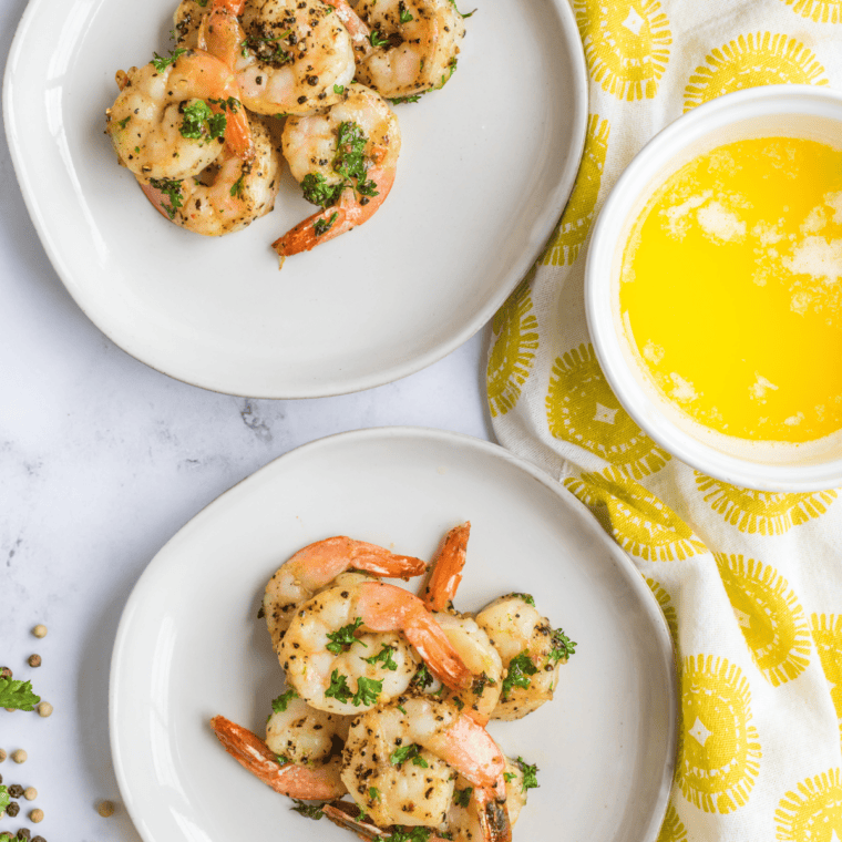 Copycat McCormick lemon pepper seasoning on saut&eacute;ed shrimp in a skillet with lemon wedges
