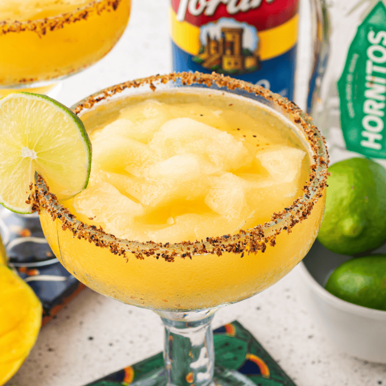 Copycat Texas Roadhouse Legendary Margarita in a black salt-rimmed glass with a lime wedge