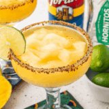 Copycat Texas Roadhouse Legendary Margarita in a black salt-rimmed glass with a lime wedge