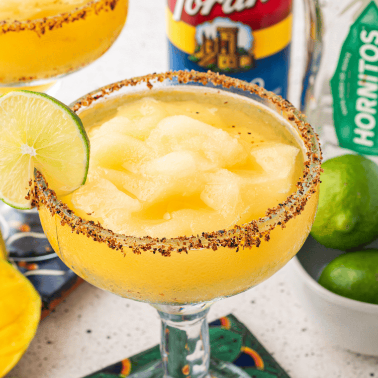 Copycat Texas Roadhouse Legendary Margarita in a black salt-rimmed glass with a lime wedge