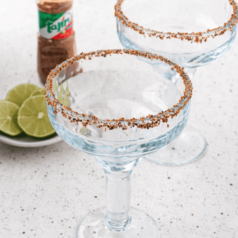 Rocks glass rim being dipped in black lava salt for a Texas Roadhouse-style margarita