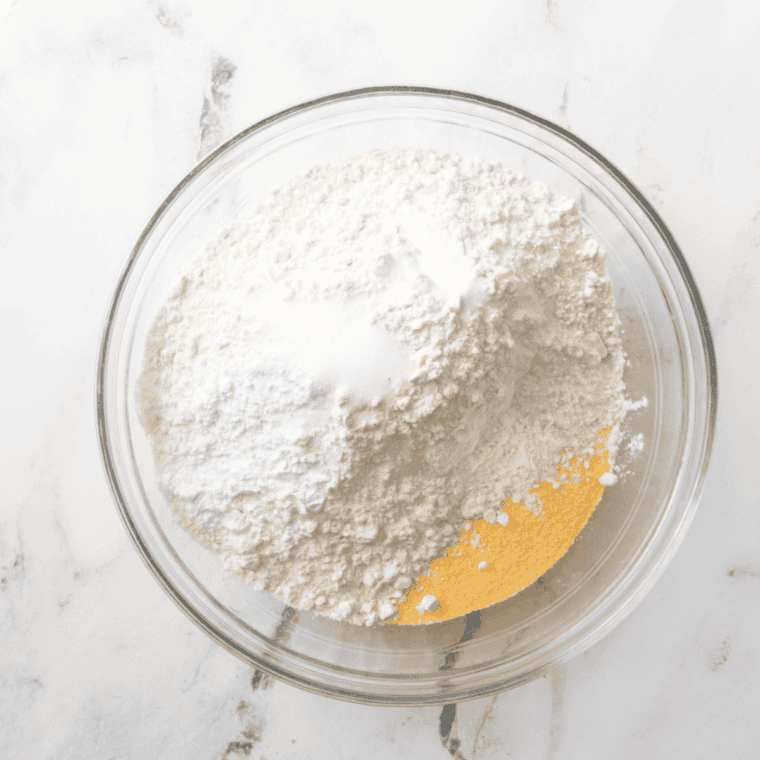 Whisking flour, cornmeal, sugar, baking powder, and salt in a bowl