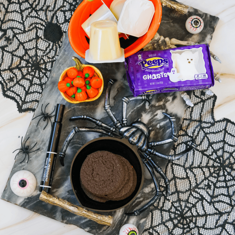 Ingredients for Halloween pudding cups: pudding cups, chocolate cookies, candy pumpkins, and ghost Peeps