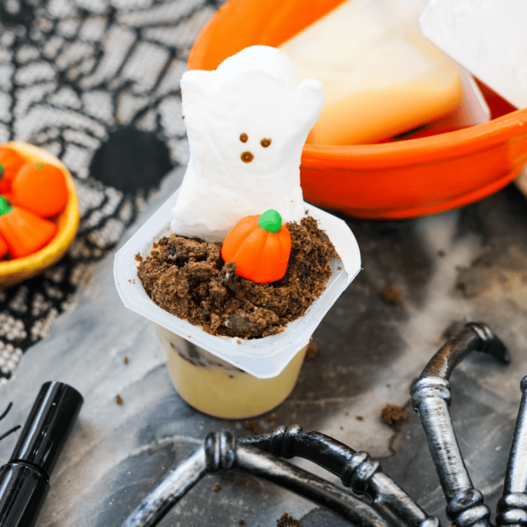 Pudding cups with little ghost faces drawn on using a food-safe marker