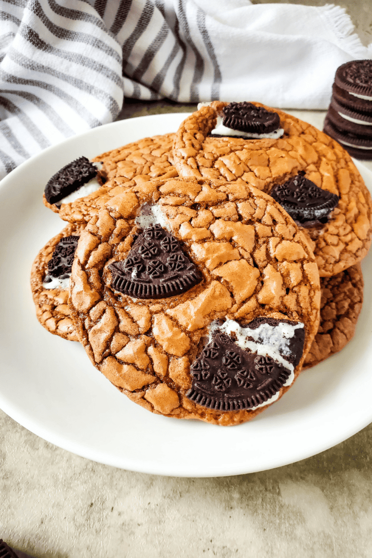 Easy Oreo brownie cookies with crinkly tops and Oreo pieces cooling on parchment paper