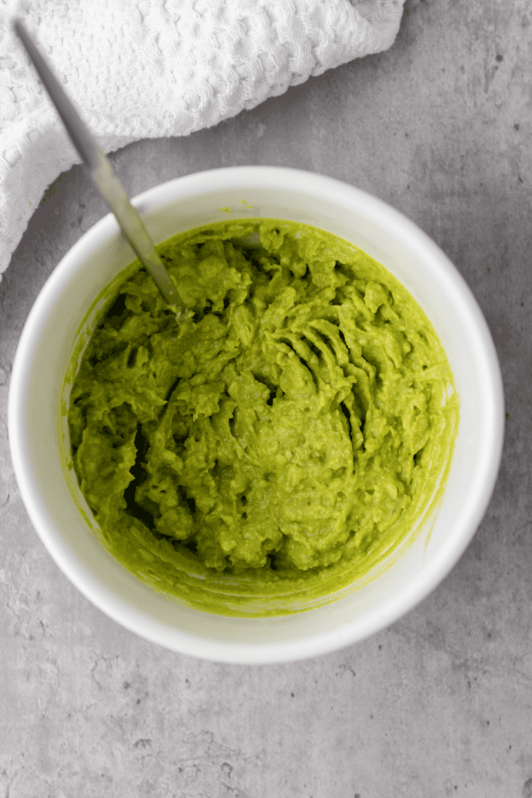 Mashing avocado with a fork into chunky dairy-free guacamole