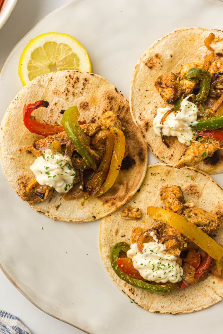 McCormick copycat fajita seasoning blend displayed in a white bowl with individual spices arranged nearby.